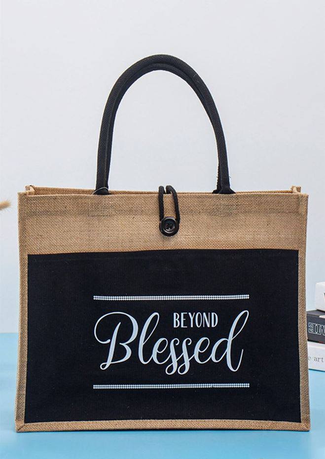 Black-panel jute tote with rope handles and printed slogan